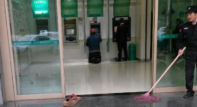 民工怕弄脏银行地板拖鞋跪地取款 保安:没事我再拖