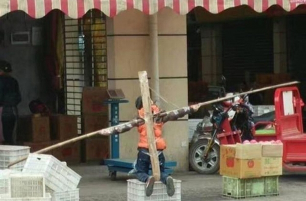 男孩当街被跪绑成十字架 父亲：开个玩笑而已