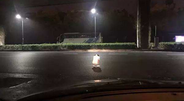 好感动！女子半夜蹲马路中间哭 暖心司机为其点亮车灯