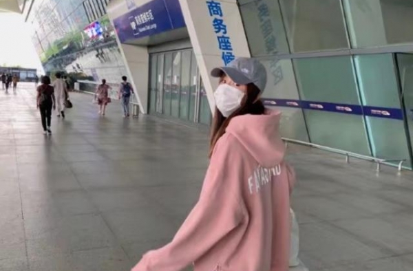 张子萱坐高铁回京看女儿，穿粉色卫衣显少女，为避免争议脚下垫纸